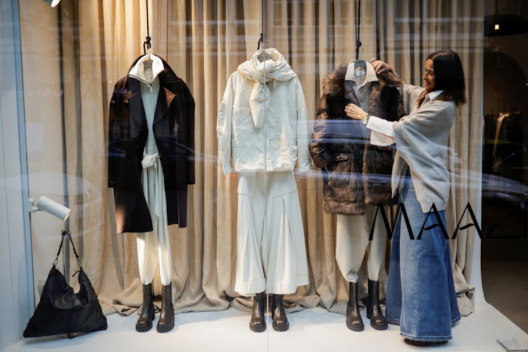 Marian Fernandez, 56, a former employee of Inditex, rearranges clothes at the store window display of her fashion shop Maazi in downtown A Coruna, in northern Spain. File photo: MIGUEL VIDAL/REUTERS