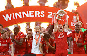 Liverpool's Jordan Henderson lifts the trophy as they celebrate after winning the FA Cup.