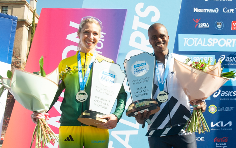 Two Oceans Ultra Marathon winners Gerda Steyn and Givemore Mudzinganyama at the finish at UCT Rugby Fields in Cape Town on April 15 2023.