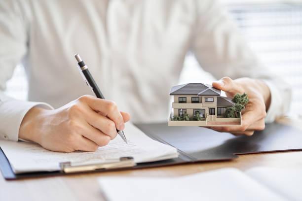 Asian businessman making a real estate contract Asian businessman making a real estate contract property solicitor stock pictures, royalty-free photos & images