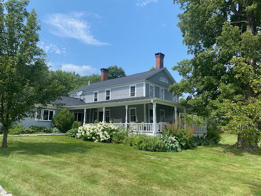 Buy this luxury house in Hartland (United States) - Gray house with porch, lush garden