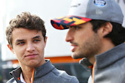 McLaren F1 drivers Lando Norris and Carlos Sainz talk in the paddock before practice for the F1 Grand Prix of Great Britain at Silverstone on July 12, 2019 in Northampton, England.