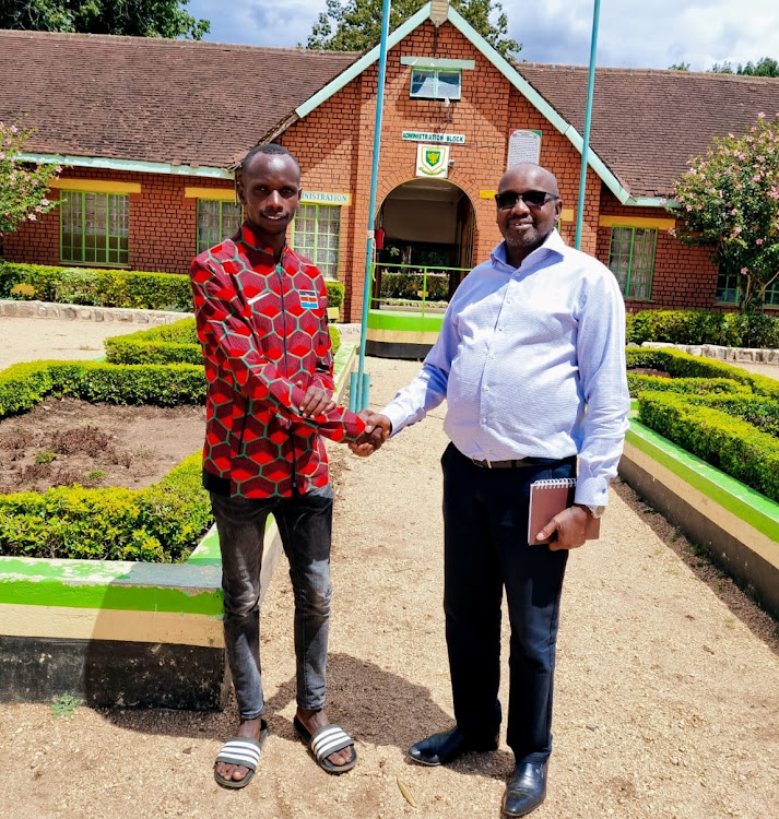 Jacob Krop (left) shaking hands with Athletics Kenya Youth and Development chairman Barnaba Korir (Right). The duo mate during the visit at the Chewoyet Athletics Training Camp last week in West Pokot.