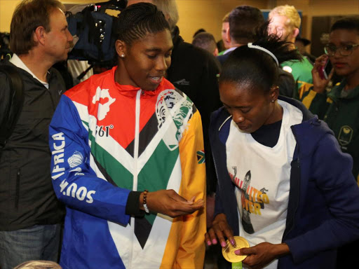 South Africa's Rio 2016 Summer Olympic Games gold medalist Caster Semenya (L) passes her medal to her partner Violet Raseboya after arriving at the OR Tambo International Airport in Johannesburg, South Africa August 23, 2016 /REUTERS