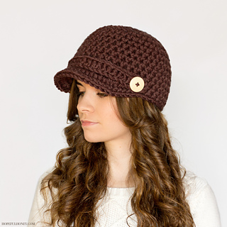 woman wearing a crocheted newsboy hat in front of a white background