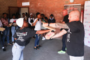 A pupil at Itirele-Zenzele Secondary school punches through blocks of wood during a self-defence class.