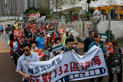 Protesters are required to wear numbered lanyards around their necks as they protest against a land reclamation and waste transfer station project during one of the first demonstrations to be formally approved since the enactment of a sweeping national security law, in Hong Kong, China.