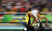 2016 Rio Olympics - Athletics - Semifinal - Men's 200m Semifinals - Olympic Stadium - Rio de Janeiro, Brazil, August 17, 2016. Usain Bolt (JAM) of Jamaica and Andre De Grasse (CAN) of Canada smile as they compete.