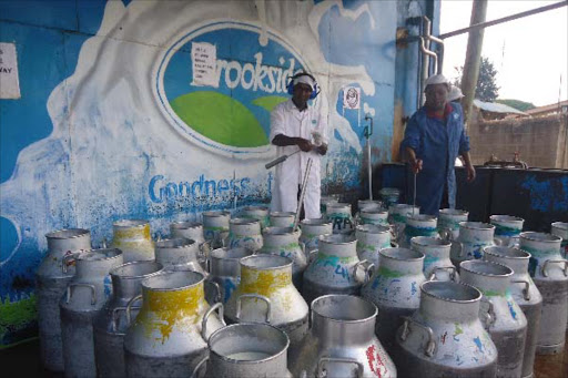 Workers prepare milk for sale at Brookside's cooling plant in Maragua