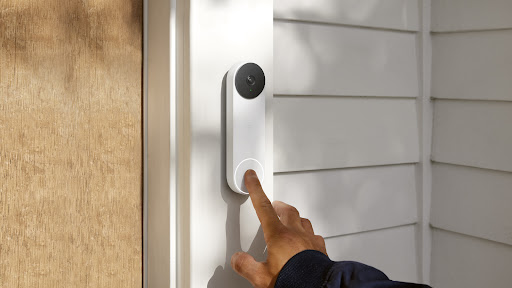 An image of house visitor pressing the button of a smart video doorbell.