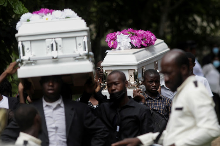 People carry coffins during the funeral of four family members after the earthquake that took place on August 14, in Marceline near Les Cayes, Haiti, on August 21, 2021.