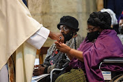 Leah Tutu, wife of late Archbishop Desmond Tutu, receives sacramental bread during his state funeral at St. George's Cathedral in Cape Town.