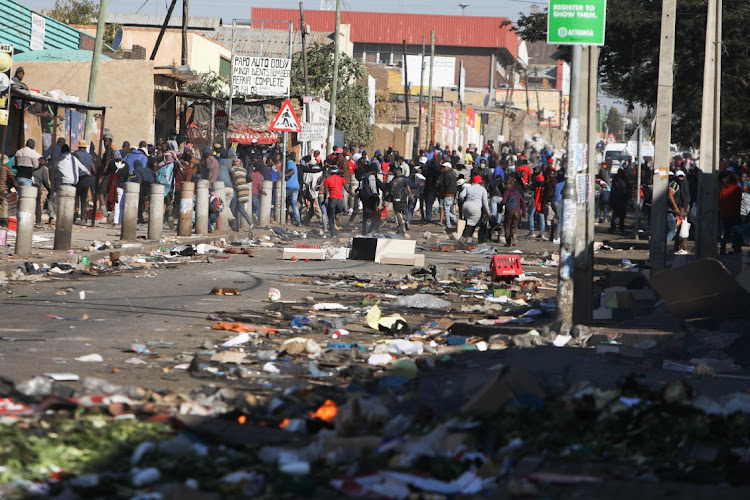 Members of the police respond to looting in parts of Alexandra Township, 12 July 2021, in Johannesburg