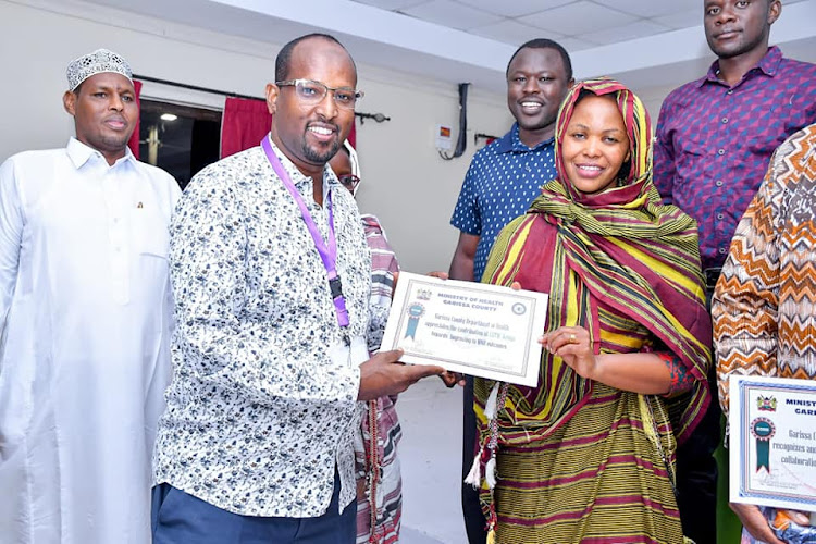 Garissa County Referral Hospital CEO Ahmed Diis awards Lucy Mwangi as the best-performing mentor in emONC mentorship 2022