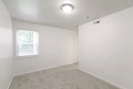 Bedroom with plush carpet, large window, dome lighting, and white walls