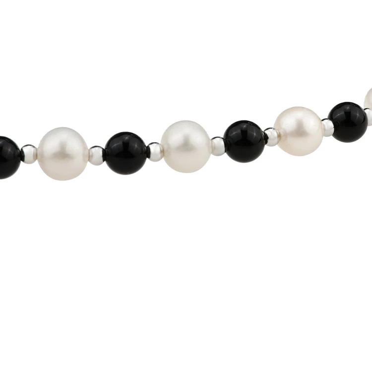 Natuurlijke zoetwater parelketting met zwarte agaat en kruis hanger. Een stijlvol sieraad met een spirituele betekenis en elegant design.