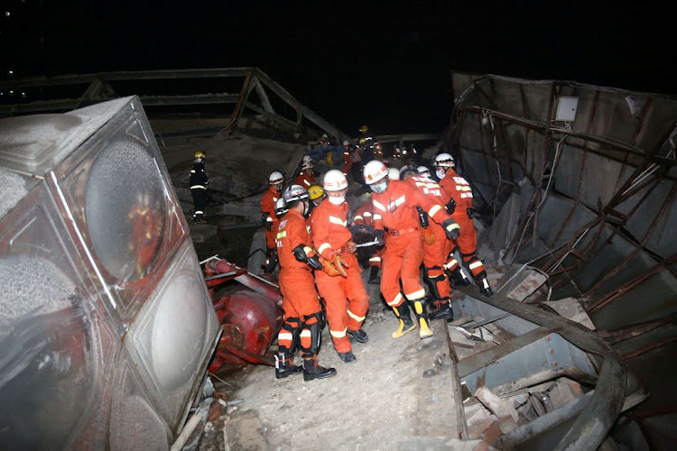 Rescue workers move injured people on the site where a hotel being used for the coronavirus quarantine collapsed,in the southeast Chinese port city of Quanzhou, Fujian province, China, on March 7 2020.