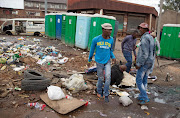 Mthintho Bhengu (who would be convicted of murder), Sfundo Mzimela (guilty of murder) and Sizwe Mngomezulu (who would be released by the court) leave a beaten and battered Emmanuel Sithole on the ground. This picture was taken before another young man, who is a minor and thus cannot be identified, came running with a large knife.