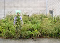 man in paars hemd en takken van de struiken, waartussen hij staat, op de borst. foto: © Matthew Cowan