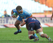 Matt Philip of the Melbourne Rebels tackles Pierre Schoeman of the Vodacom Blue Bulls during the Super Rugby match at Loftus Versfeld Stadium.