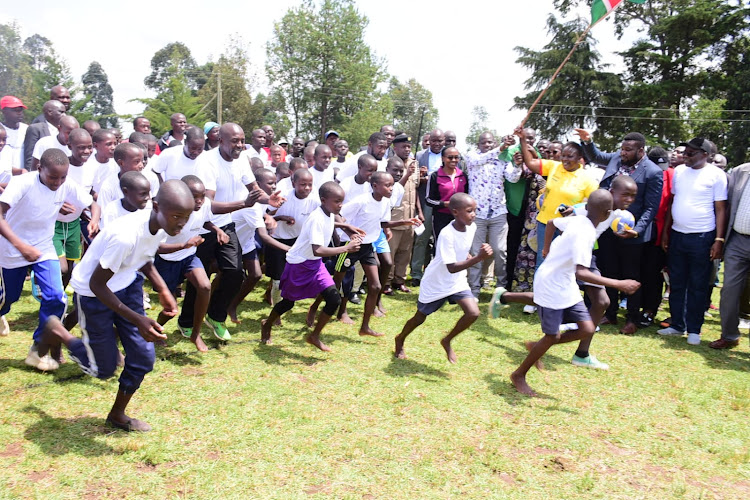 Uasin Gishu governor Jonathan Bii flagging off young athletes during the launch of Chepsaita Youth Athletics Training Club in Turbo, Uasin Gishu County