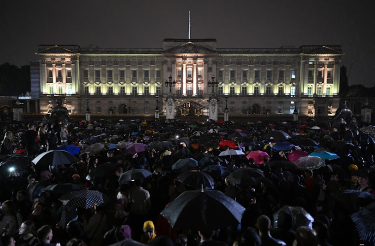 Crowds gather in front of Buckingham Palace to pay their respects to the late queen.