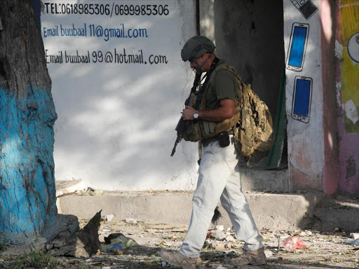 A foreign security expert from Bancroft inspects the scene of a car explosion on Al Mukaram street in Mogadishu, Somalia, September 11, 2017. /REUTERS