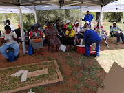 Families of the Mamelodi 10 look on as the body of the last victim is exhumed at Winterveld cemetery.