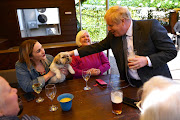 British Prime Minister Boris Johnson pets a dog in the beer garden during a visit to The Mount Tavern Pub and Restaurant on the local election campaign trail in Wolverhampton in April. File photo.