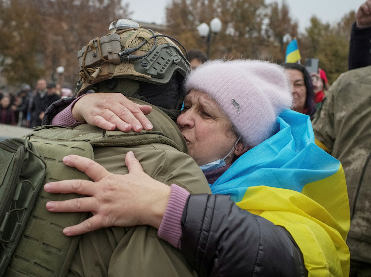 A local resident hugs Ukrainian serviceman as people celebrate after Russia's retreat from Kherson, in central Kherson, Ukraine, November 12 2022. Picture: REUTERS/LESKO KRONPLITZ