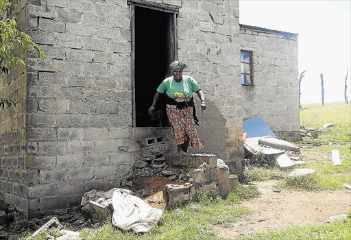 DANGEROUS: Tholakele Goyi, a resident of Walter Sisulu Township in Elliotdale, battles to get in and out of her crumbling RDP house Picture: SIKHO NTSHOBANE