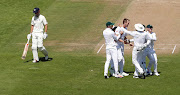 South Africa's Chris Morris celebrates the wicket of England's Alastair Cook with team mates.