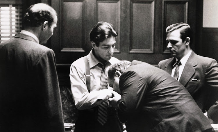 Clemenza (Richard Castellano) kisses the hand of the new 'Godfather', Michael Corleone (Al Pacino), in the last scene of 'The Godfather'. The movie has remained a firm favourite with fans and critics alike and inspired countless imitations and tributes.