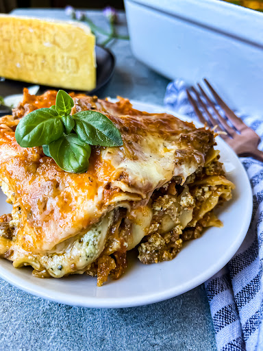 The Best Pesto Ricotta Lasagna served on a plate with parmesan 