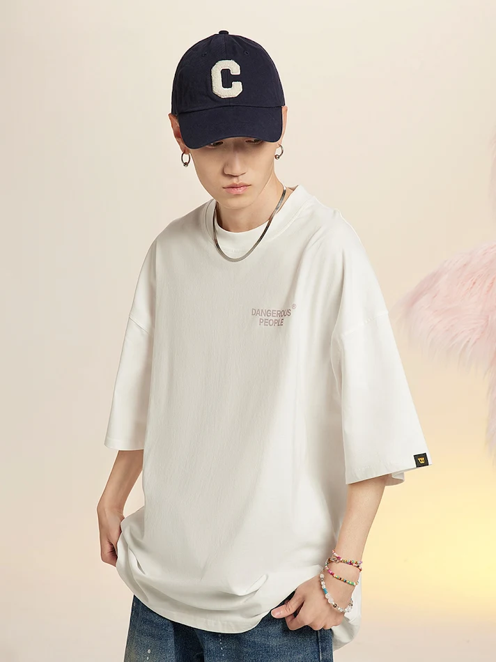 Camiseta masculina folgada com efeito splash de tinta, manga curta e modelagem paper bag, perfeita para um visual despojado e estiloso.