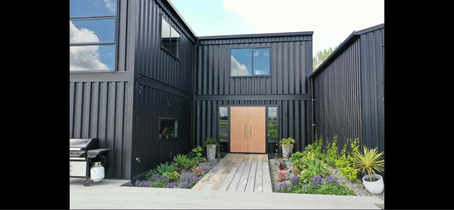 David Wade's design of black exteriors perfectly contrasts the New Zealand greenery.