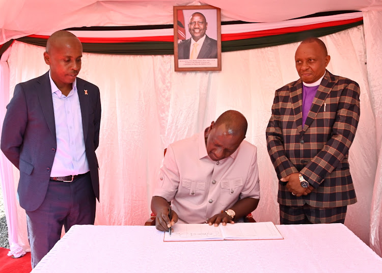 President William Ruto signing the visitors book and Dagoretti South MP John Kiarie at Revival Sanctuary of Glory in Riruta Satellite, Dagoretti South, on October 22, 2023