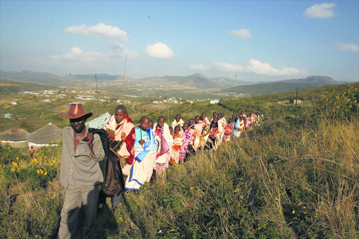 A traditional nurse leads a group of initiates back to their village. Many initiates die of thirst because they are under the false impression that their wounds will heal faster if they don't drink water.