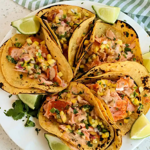 Easy Salmon Tacos made with pan-seared salmon served on corn tortillas with delicious mango salsa and chipotle ranch.