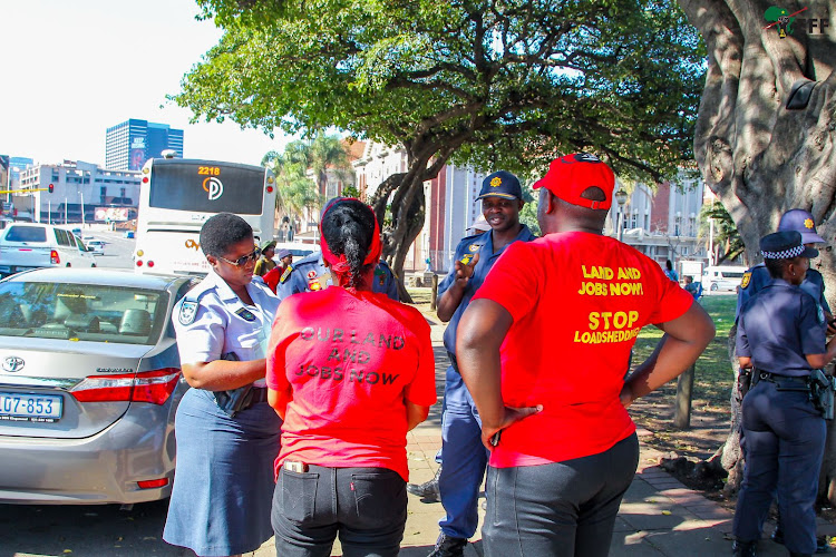 Metro police and police chat to EFF officials ahead of a march through the Durban city centre on Tuesday.