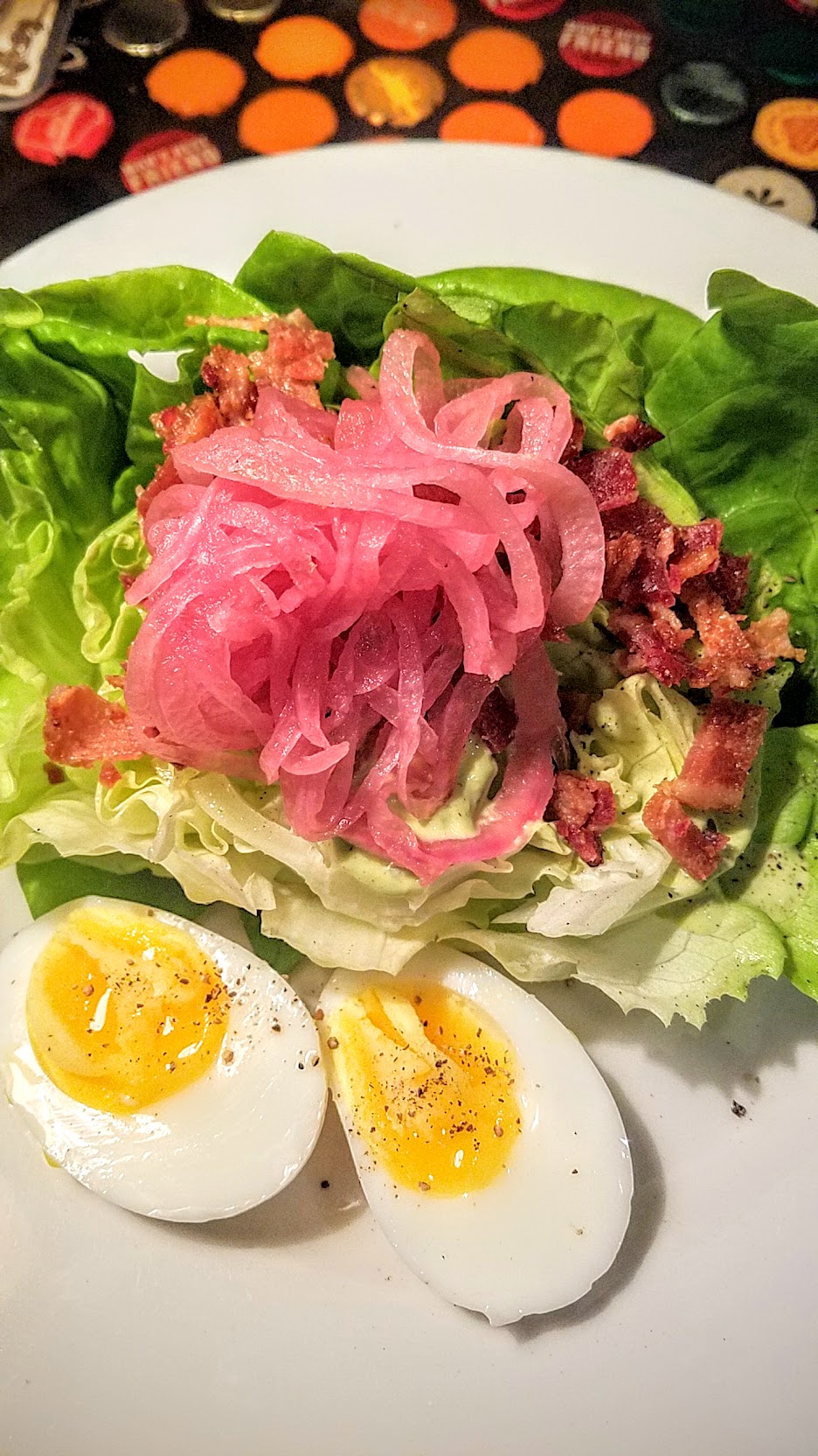 Example Food at Saraveza Butter lettuce salad with green goddess dressing, soft boiled egg, bacon, and red onion pickle