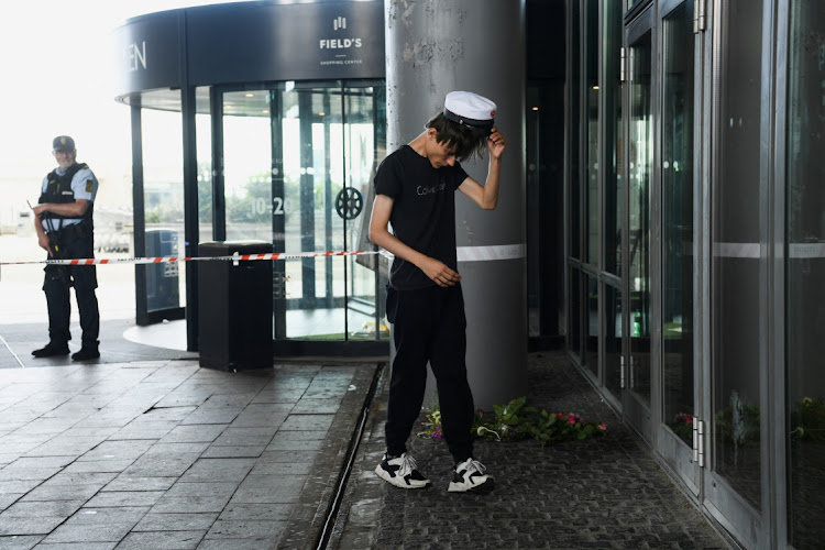 Nicolaj, 20, reacts after laying down flowers next to an entrance of the Field's shopping centre on July 4 2022, a day after a shooting occurred at the mall, in Copenhagen, Denmark. Picture: REUTERS/ANNEGRET HILSE