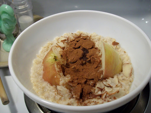 A bowl of Oatmeal with apple, almonds and cinnamon.