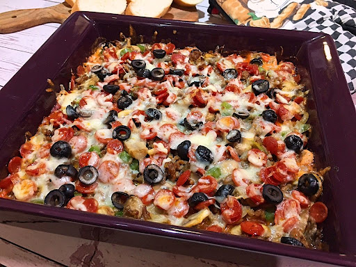 A delicious pizza dip with cheeses, mini pepperoni, black olives, Italian sausage and veggies.