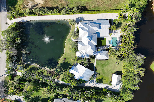 Aerial view modern house with pond in this luxury property for sale in Naples ($9,500,000)