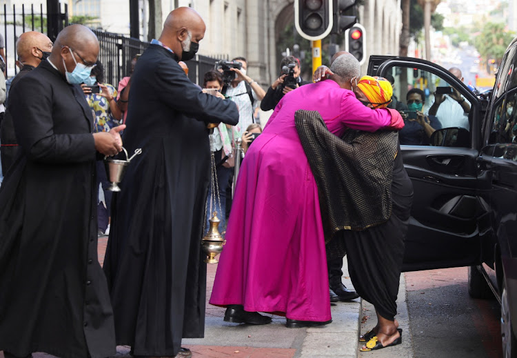 Archbishop of Cape Town Thabo Makgoba hugs Thandeka Tutu, daughter of Archbishop Emeritus Desmond Tutu, as the casket containing his body arrives at St George's Cathedral in Cape Town on December 30 2021.