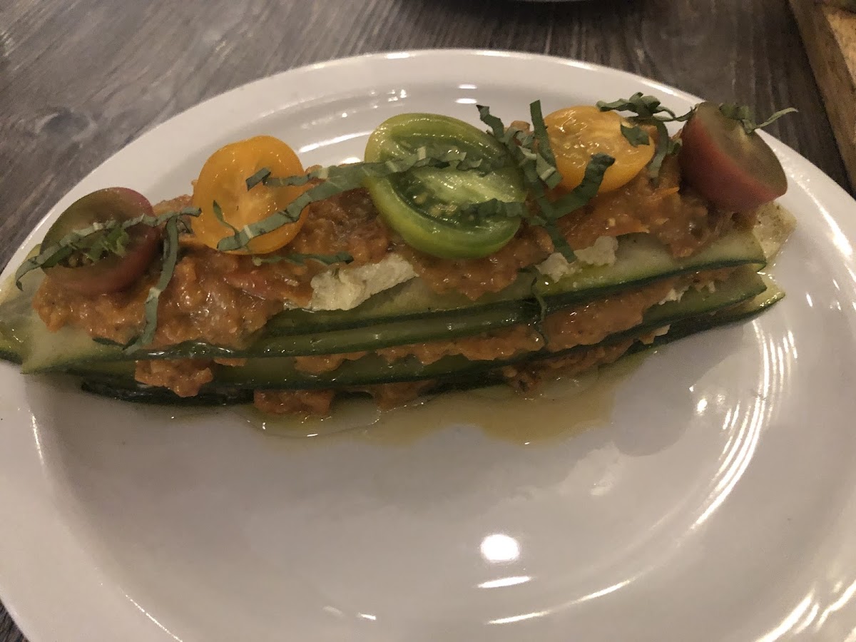 The amazing raw lasagna. White wine vinaigrette-marinated zucchini sheets with macadamia ricotta, basil-pine nut pesto, sun dried and heirloom cherry tomato sauce and basil blossom.