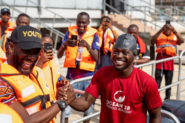 Akinrodoye Samuel shakes hands with Mobolaji Ogunlende of the Commission for Youths and Social Development, ahead of his attempt to swim the 11.8km stretch of the Third Mainland Bridge, advocating for the theme 'Swim Against Suicide And Depression' in Lagos, Nigeria, on March 30 2024.