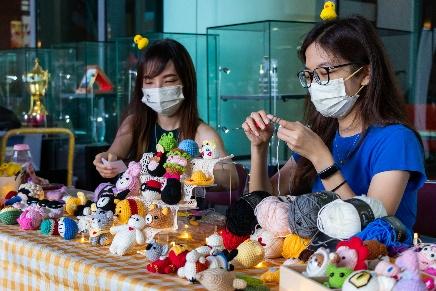 Two women wearing face masks and knitting

Description automatically generated