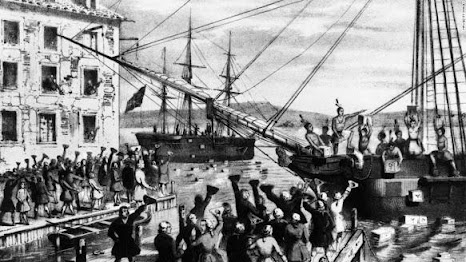 A group of Bostonians dressed as Native Americans dump crates of imported British tea into Boston Harbor as a protest against the British Tea Act in 1773.